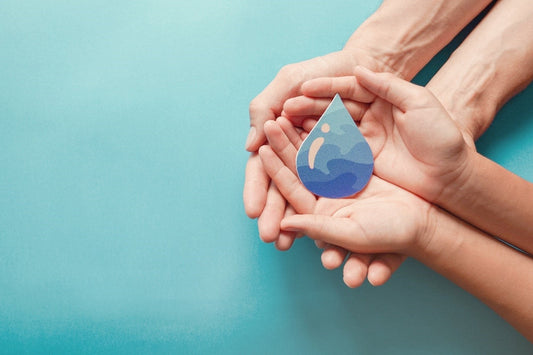 Two hands holding a paper water droplet